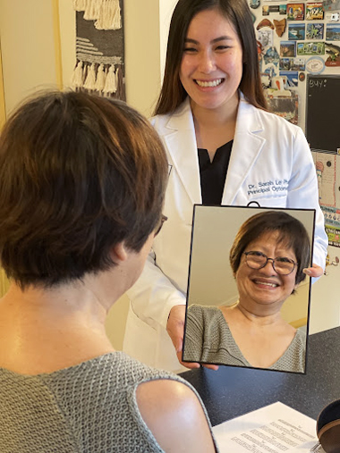 Patient trying on glasses with optometrist at home